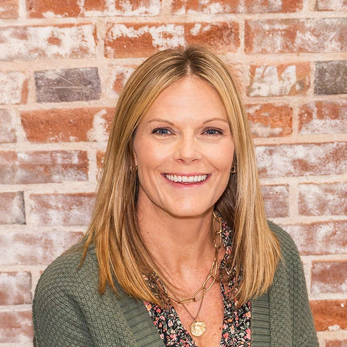 Close-up portrait of Ashley Kopp, LCSW, smiling warmly in her office, representing her empathetic counseling services and commitment to women’s mental health and wellness.